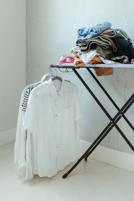 A person cleaning a kitchen shelf with a spray bottle and cloth, keeping it hygienic and spotless.